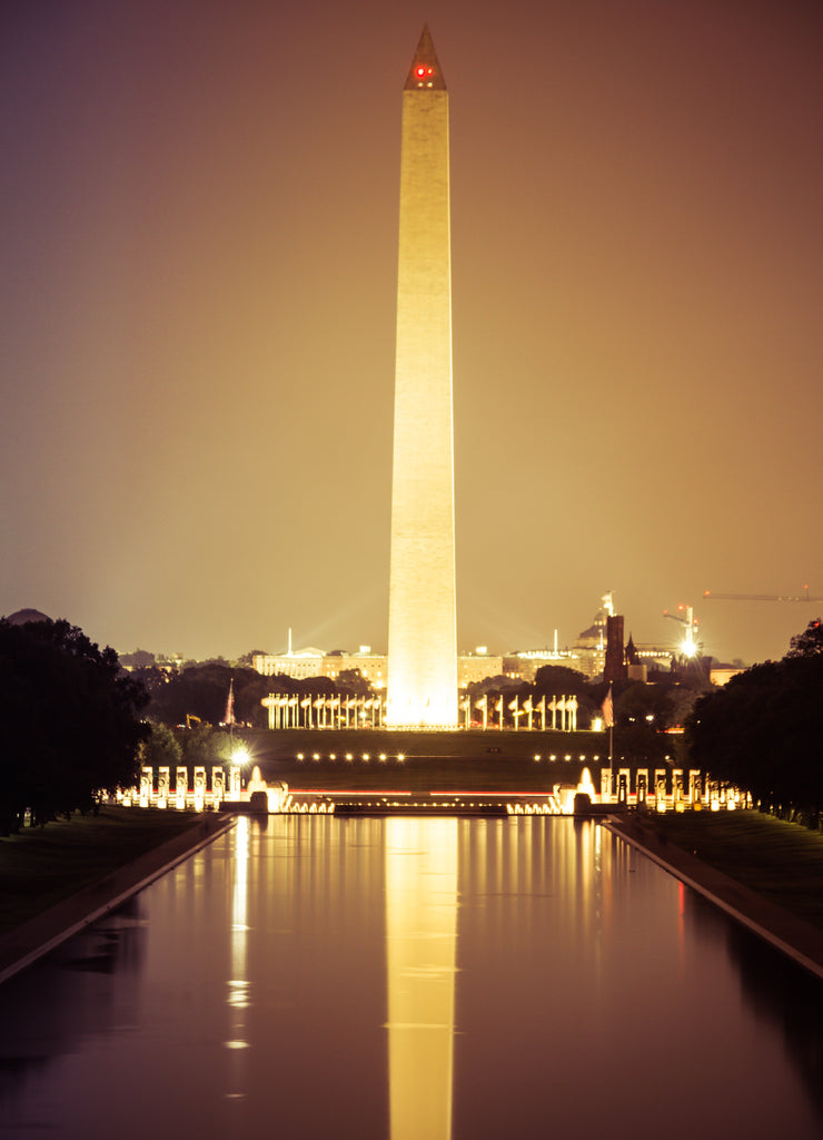The Washington Monument at night with its image reflected in the National Mall reflecting pool