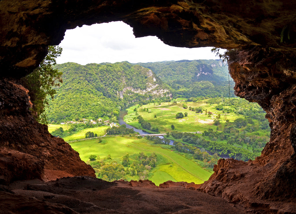 Window Cave (Cueva Ventana) in Arecibo near San Juan, Puerto Rico. View through lush green scenery through the cave opening shaped like a window that is at the end of hike