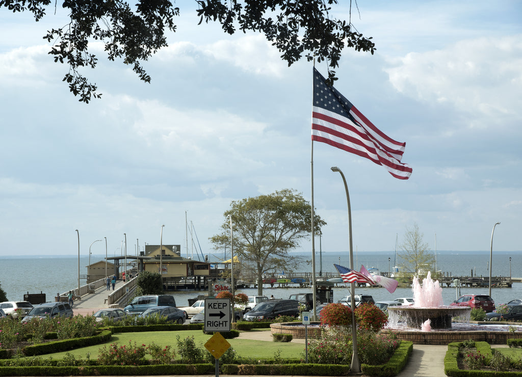 Fairhope Pier on Mobile Bay in Baldwin County Alabama USA. A fountain that supports cancer awareness gushes pink water