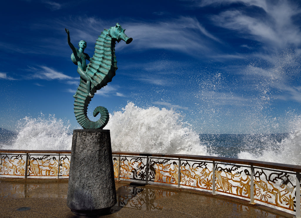 The boy on a seahorse sculpture Puerto Vallarta Malecon with lapping of the Pacific Ocean, Mexico