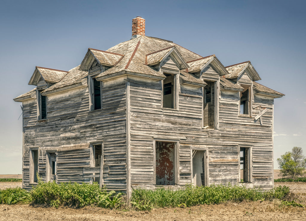 Abandoned old house in rural Nebraska in the middle of a field