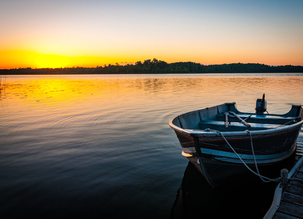 Fishing boat on tranquil lake at sunset in Minnesota