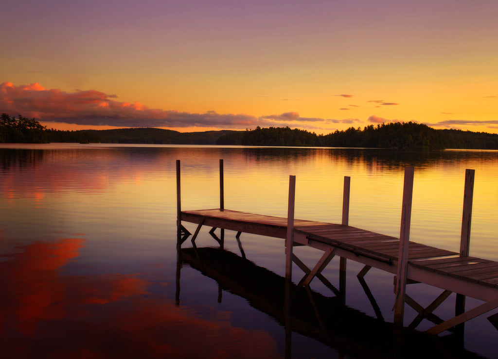 Old pier in a lake at the sunset in Maine