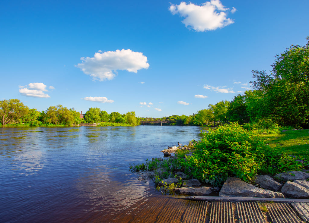 Beautiful sunny spring or summer afternoon at the Androscoggin river in Auburn Maine. Looking across the river at Auburn Maine