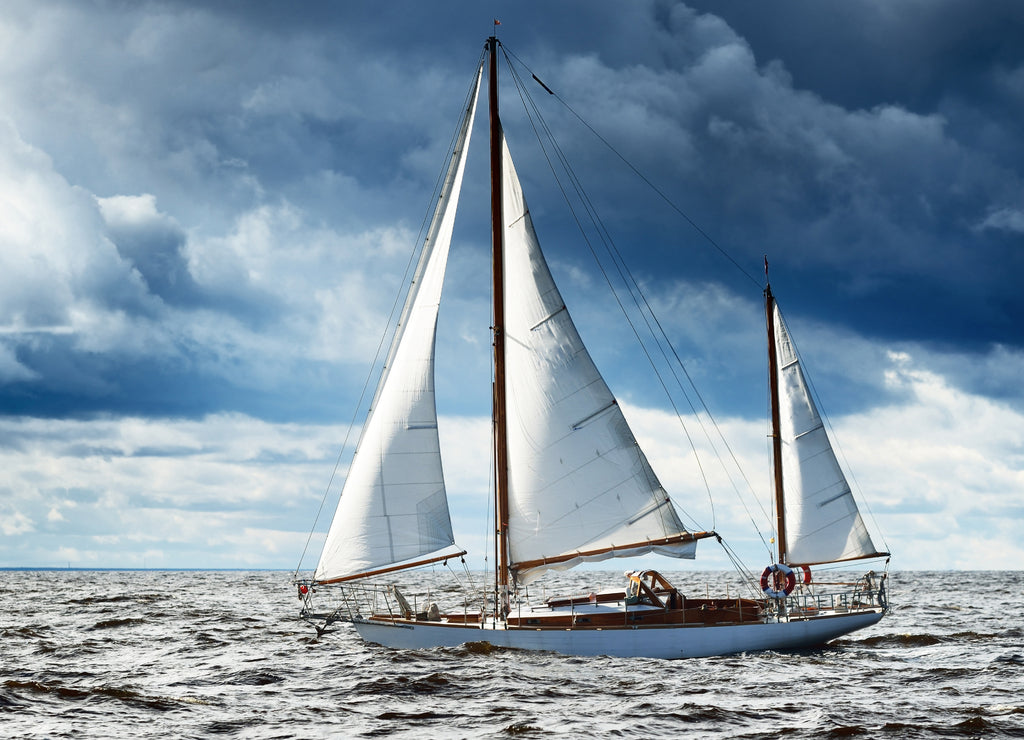 Vintage wooden sailboat (yawl) sailing in an open sea, coast of Maine USA