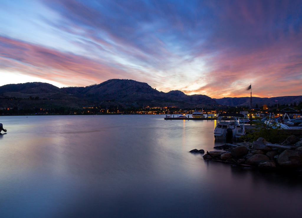 Dawn over Chelan Lake in Washington. Colorful sky reflects in calm water