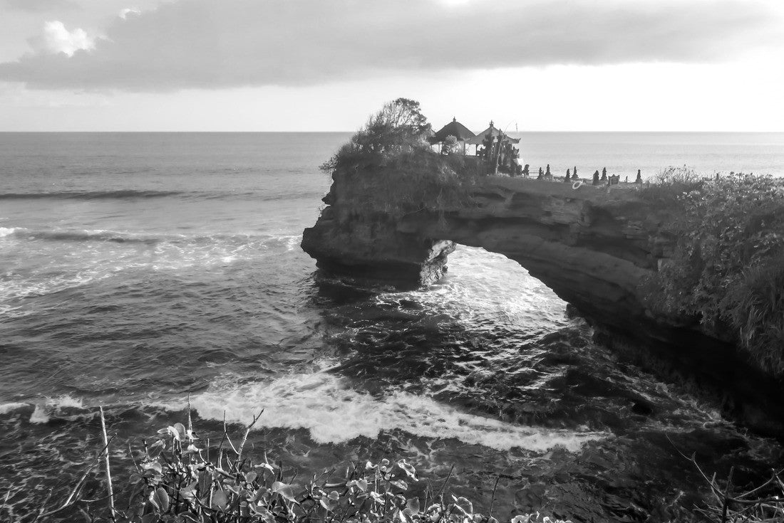 Noah Jigsaw Puzzle Cliffs in the nearby of Tanah Lot Temple, Bali, Indonesia. There is an arch in the water. The waves are splashing on the cliffs and smaller rocks. Water stays on the flat surfaces. Power of the nature in black white 2000 pieces