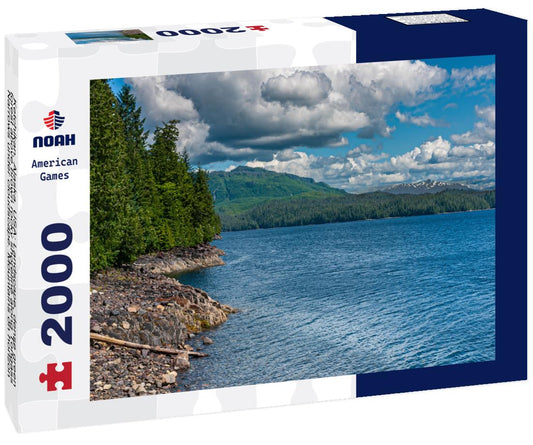 Noah Jigsaw Puzzle Ketchikan, Alaska: Landscape, dense green forest above brown rocky shoreline along Tongass Narrows under cloudscape. Mountains on horizon and blue ocean water up front 2000 pieces
