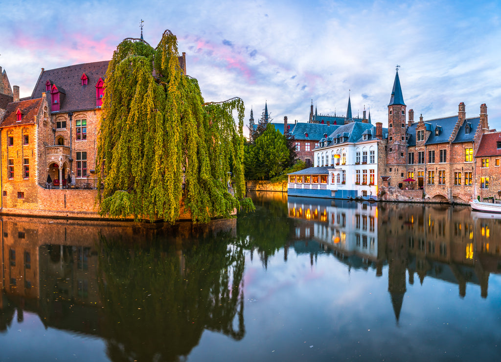 Sunset panorama Brugge city centre, often referred to as The Venice of the North, with famous Rozenhoedkaai illuminated in beautiful twilight, West Flanders province, Belgium