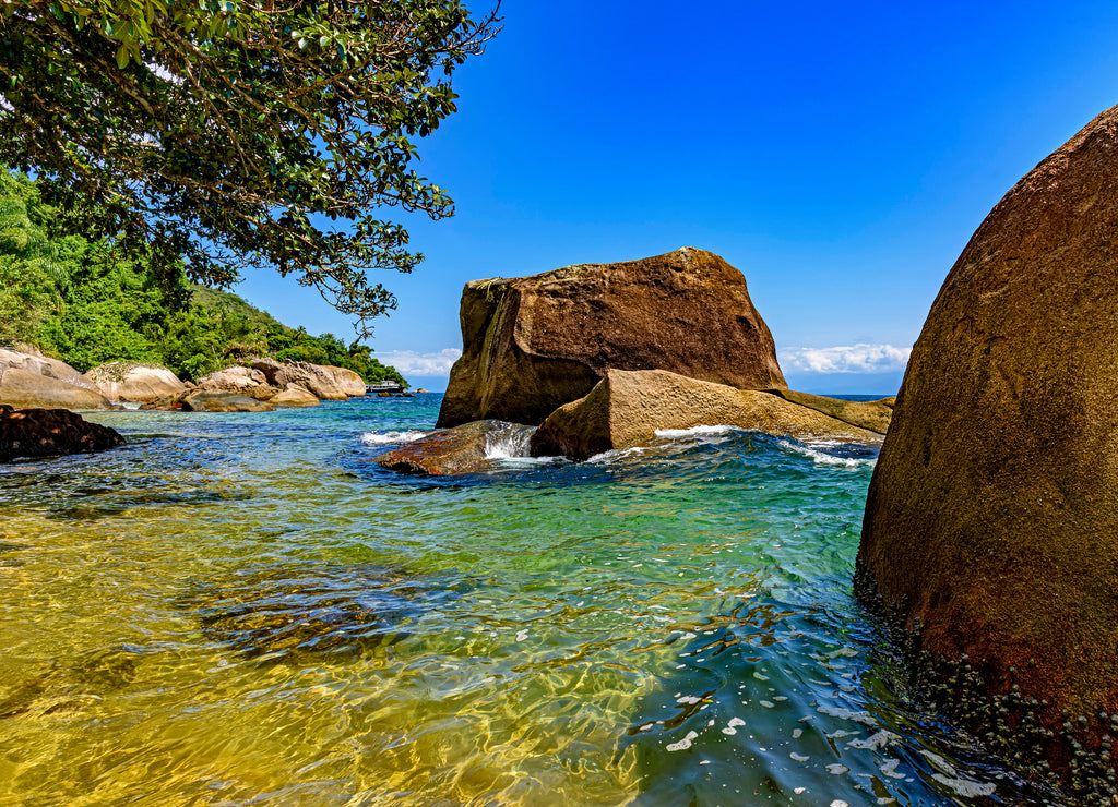 Paradisiacal beach of green and transparent waters surrounded by the forest in Ilha Grande, Angra dos Reis, Rio de Janeiro