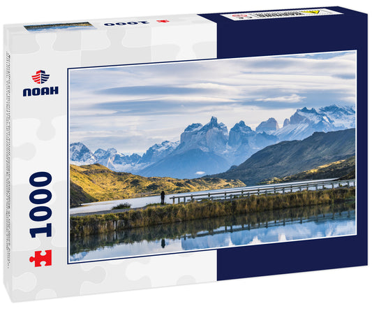 Beautiful panoramic view small people standing at the dock from the lake with Cuernos, horn mountains peak with lenticular cloud in autumn, Torres del Paine national park, south Patagonia, Chile
