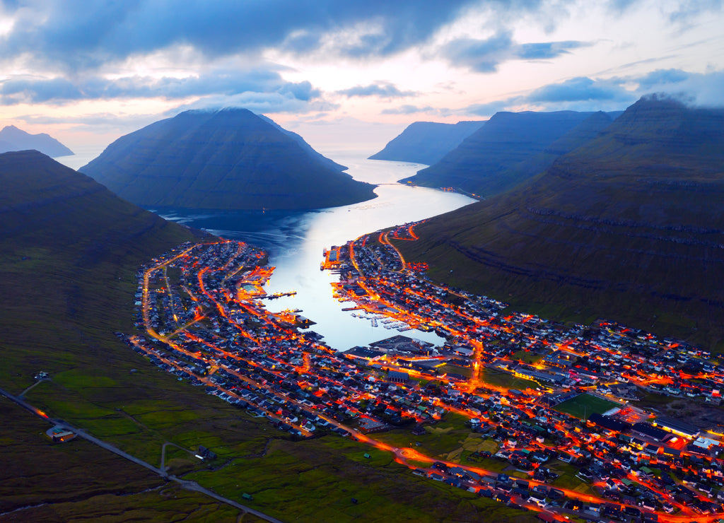 Fantastic aerial evening cityscape of Klaksvik town with glowing streets and fjord, Bordoy island, Faroe islands, Denmark