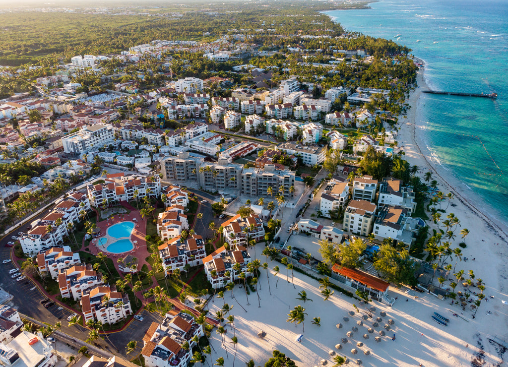Aerial drone view of beach resort hotels with pools, umbrellas and blue water of Atlantic Ocean, Bavaro, Punta Cana, Dominican Republic