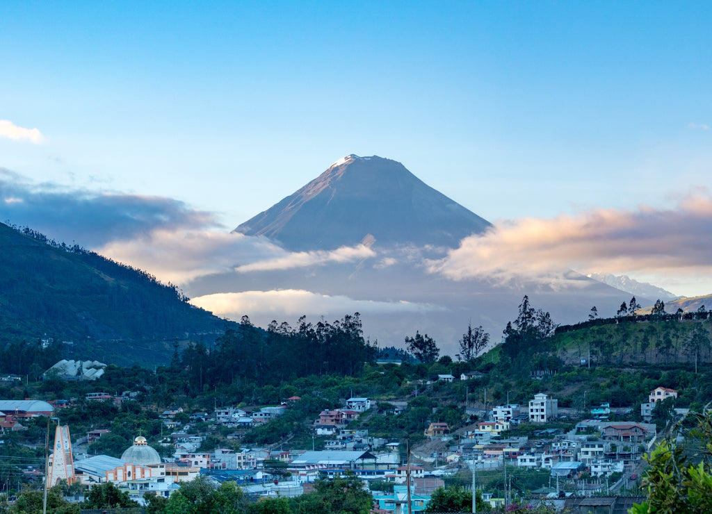 Town and volcano during sunrise in Andes of Ecuacor