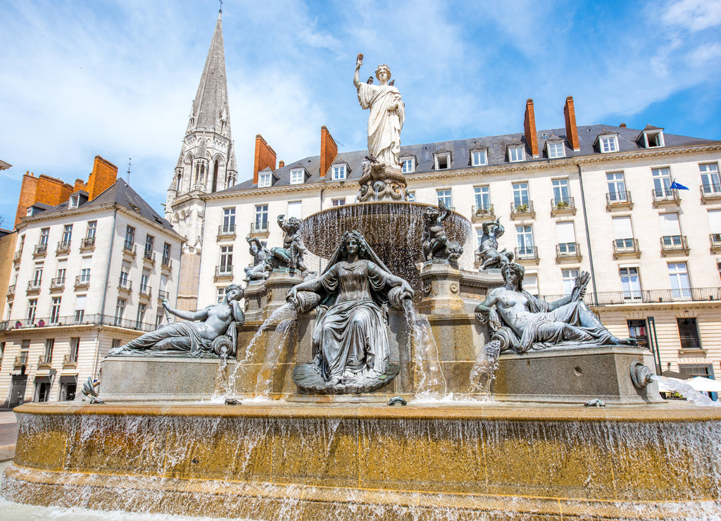 View on the Royal square with fountain and church tower in Nantes city in France