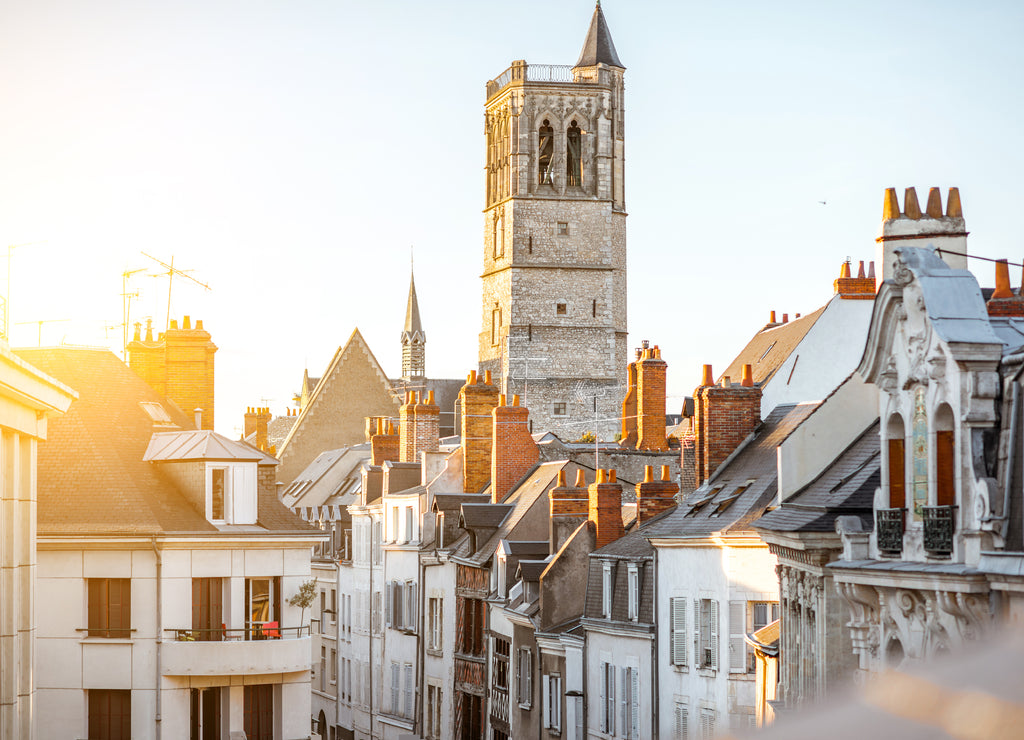 Top cityscape view on the old buildings and curch tower in Orleans city during the sunset in central France