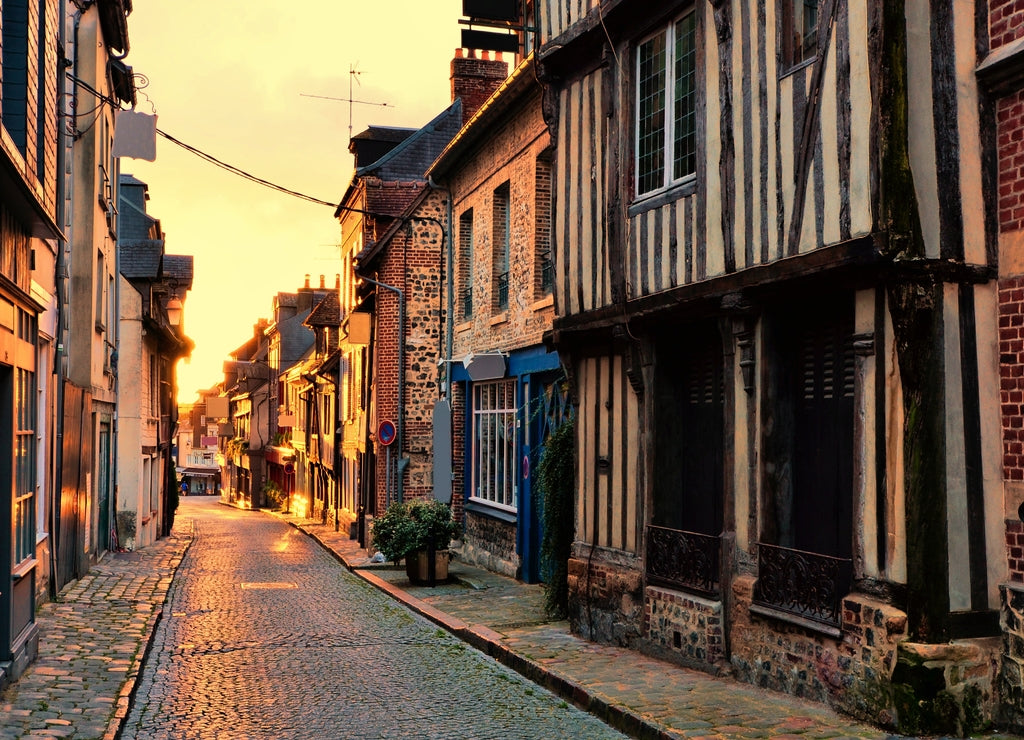 Old street in the Normandy town of Honfleur, France with light of the rising sun