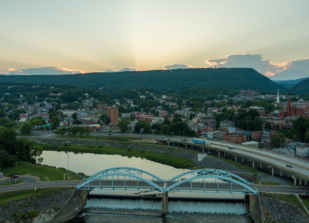 I-68 passes Cumberland, Allegany County, Md. Bridge Street crosses the North Branch of the Potomac River into Ridgeley, Mineral County, W.Va. (left), as the sun sets behind the Allegheny Mountains