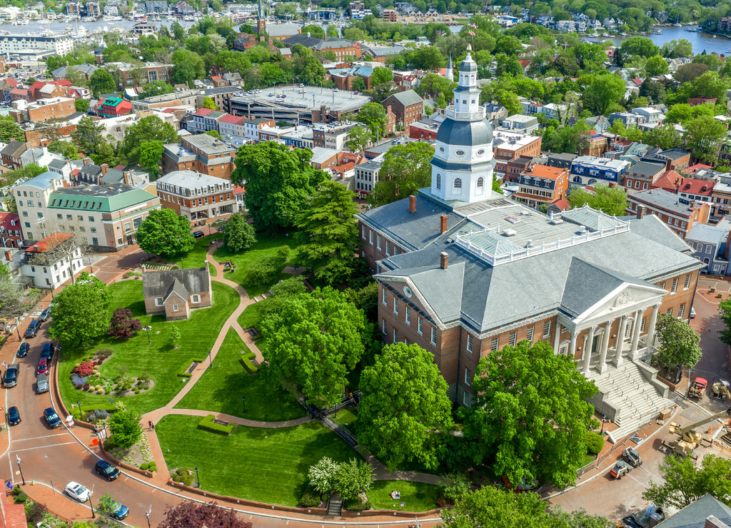 Aerial view of Maryland State House capitol building white dome and state circle with colonial houses in Annapolis on a sunny weekend afternoon