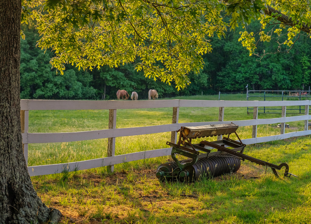 La Plata, Maryland: Sunset on the farm with a plow in front of a fence