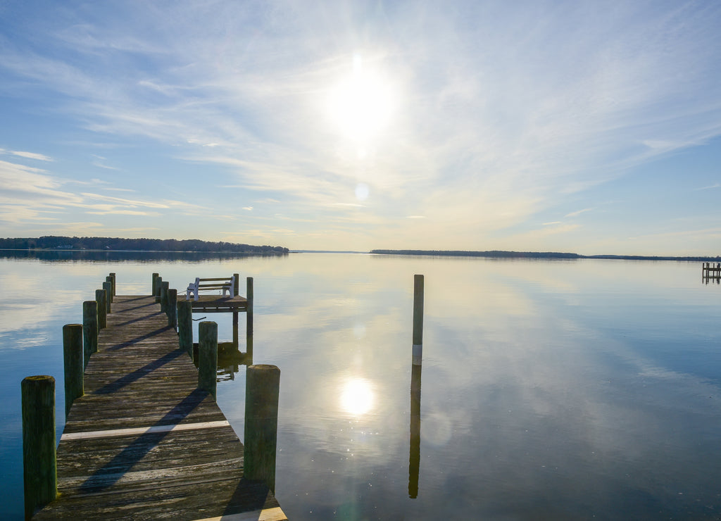 A pier juts into the mirror-like waters of Breton Bay, in Leonardtown, Maryland