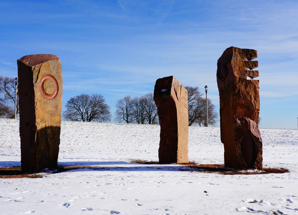 3 old vintage red stone statue structures standing at a park in Milwaukee, Wisconsin