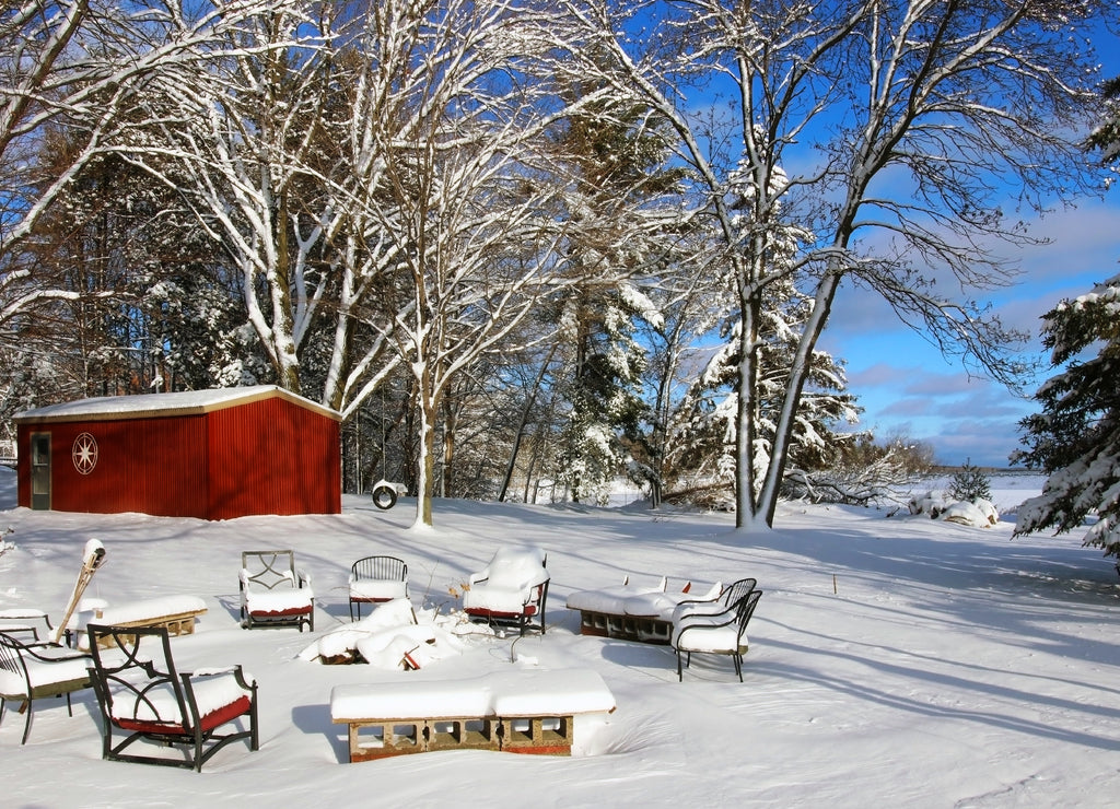 Beautiful Midwest snowy winter nature background. Scenic rural view with covered by fresh snow backyard of the private house with outdoor furniture. Wisconsin countryside, Wausau area