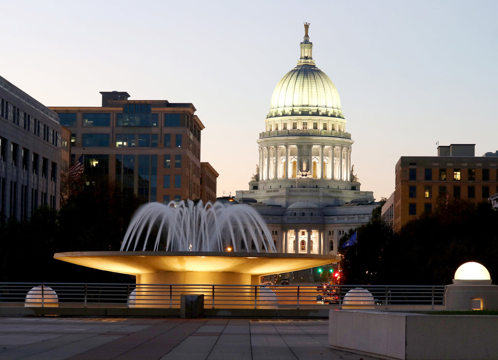 Wisconsin State Capitol building. National Historic Landmark. Madison, Wisconsin, USA. Twilight scene with illuminated fountain in the foreground. Vertical view from Monona terrace balcony