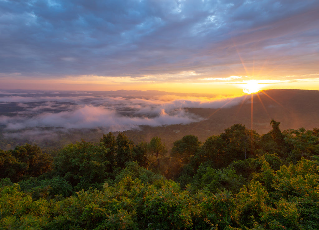 Morning sun rays through clouds and fog over mountains at Arkansas Grand Canyon Scenic Overlook