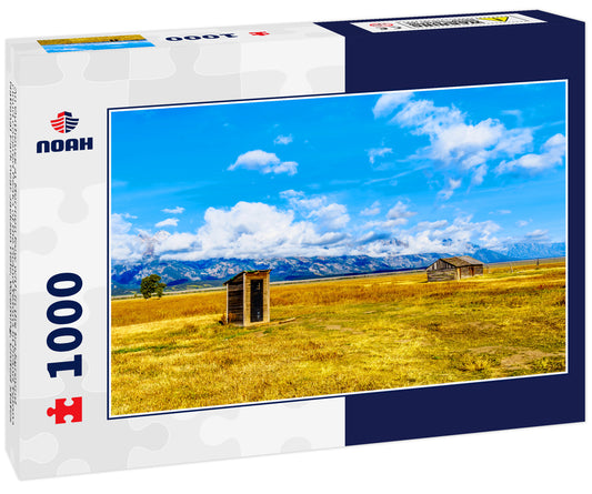 An Outhouse at Mormon Row with in the background cloud covered Peaks of the Grand Tetons In Grand Tetons National Park near Jackson Hole, Wyoming, United States