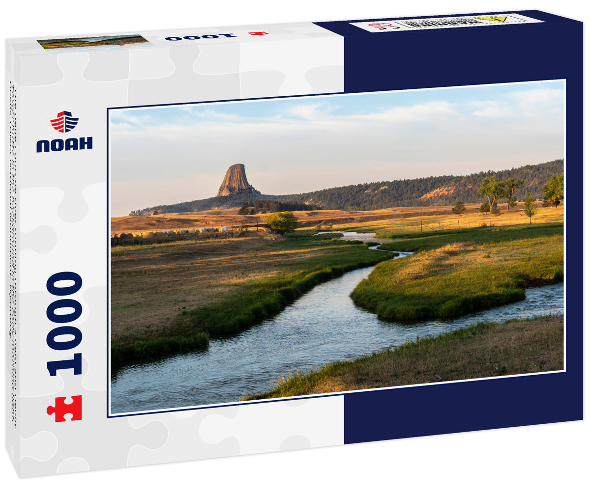 The Belle Fourche river running through a field and Devils Tower butte in the background in the early morning light, Devils Tower National Monument, Wyoming