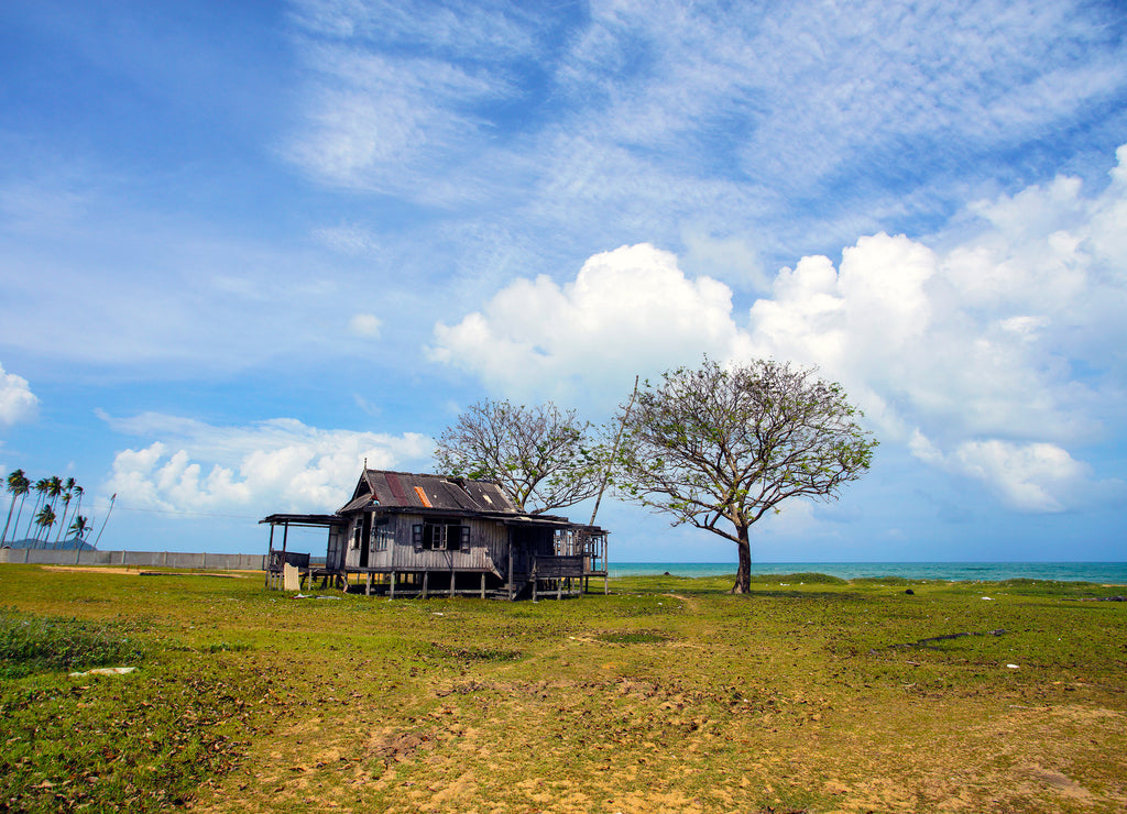 Old abandoned house under blue sky near the beach, North Dakota