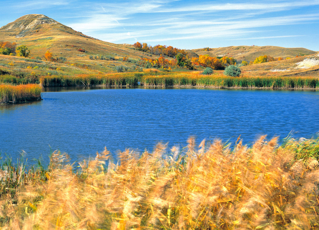 USA, North Dakota, Lewis & Clark SP. Autumn light slants over this deep blue pond in Lewis & Clark State Park, North Dakota