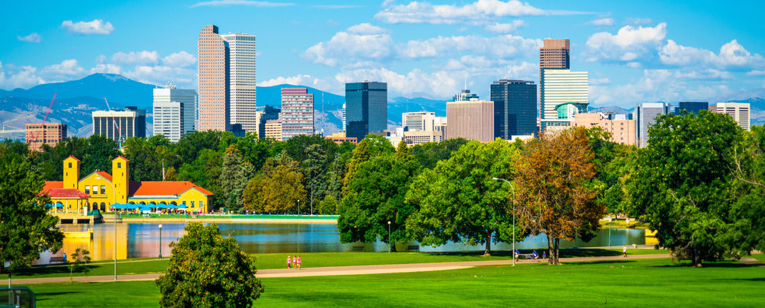 Green City Park View of Denver Colorado downtown skyline rising behind green city park tree line with Rocky Mountain background wide view 2000pc Panoramic Puzzle