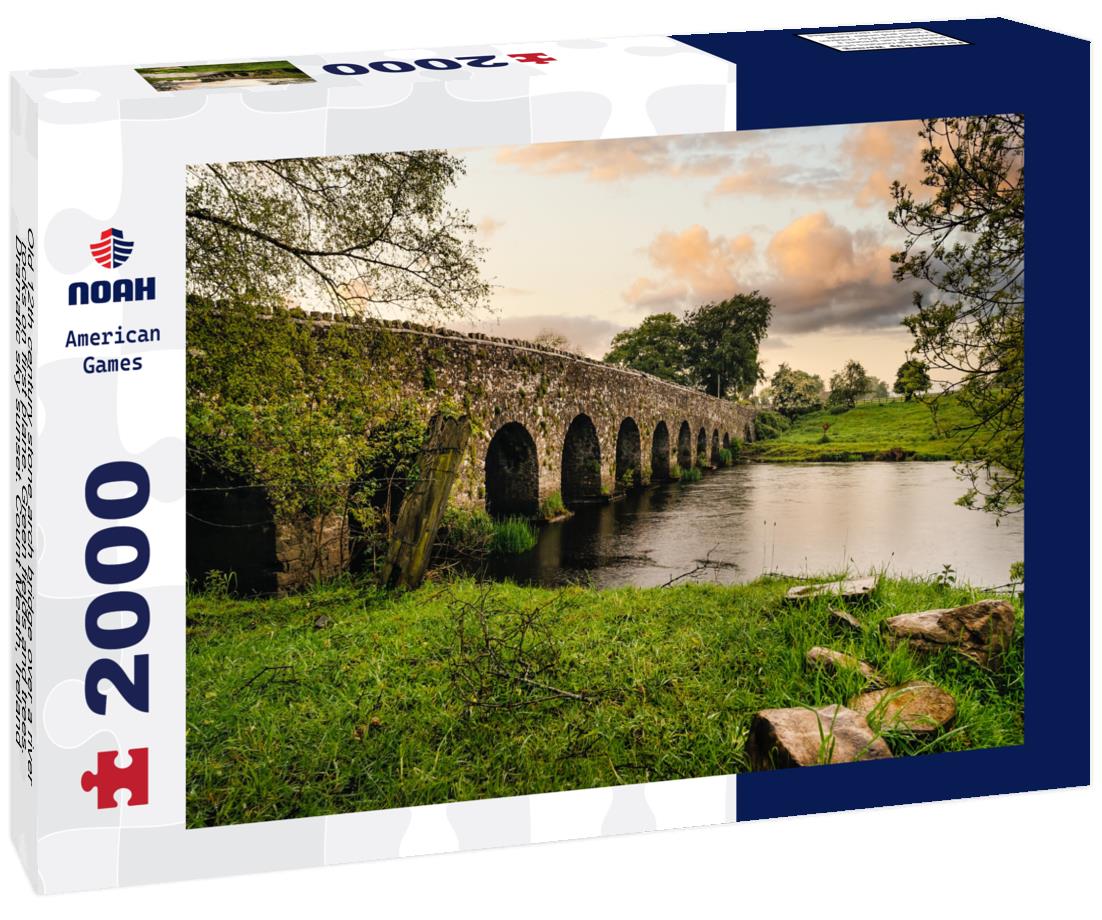 Noah Jigsaw Puzzle Old 12th century stone arch bridge over a river, rocks on first plane. Green fields and trees. Dramatic sky sunset. Count Meath, Ireland 2000 pieces