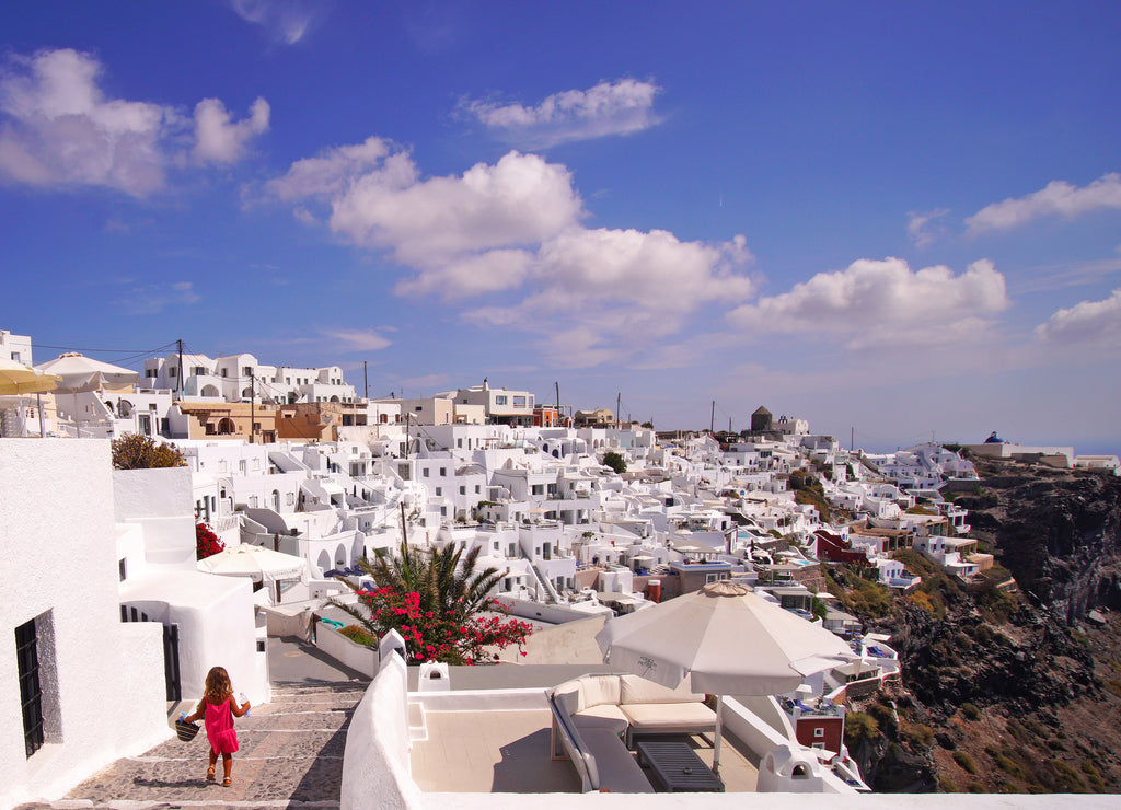A lovely little tourist goes for a walk through the streets of Santorini