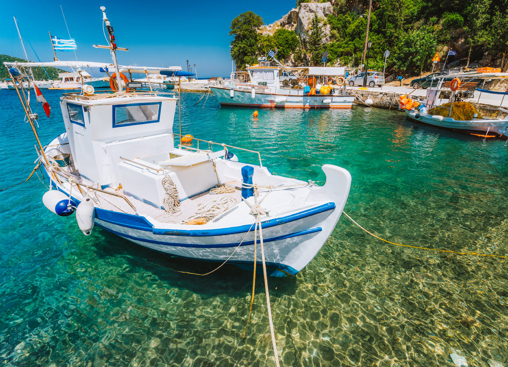 Traditional fishing boat in crystal clear Mediterranean sea cove of Ithaka island, Greece