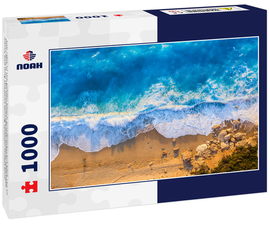 Top view of the golden beach and fluorescent blue sea of Milos Beach on the island of Lefkada, Greece, with high waves and long shadows during summer sunset time