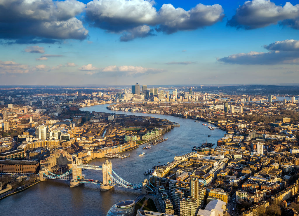 London, England - Aerial skyline of famous Tower Bridge with Red Double Decker bus and Canary Wharf skyscrapers at the background