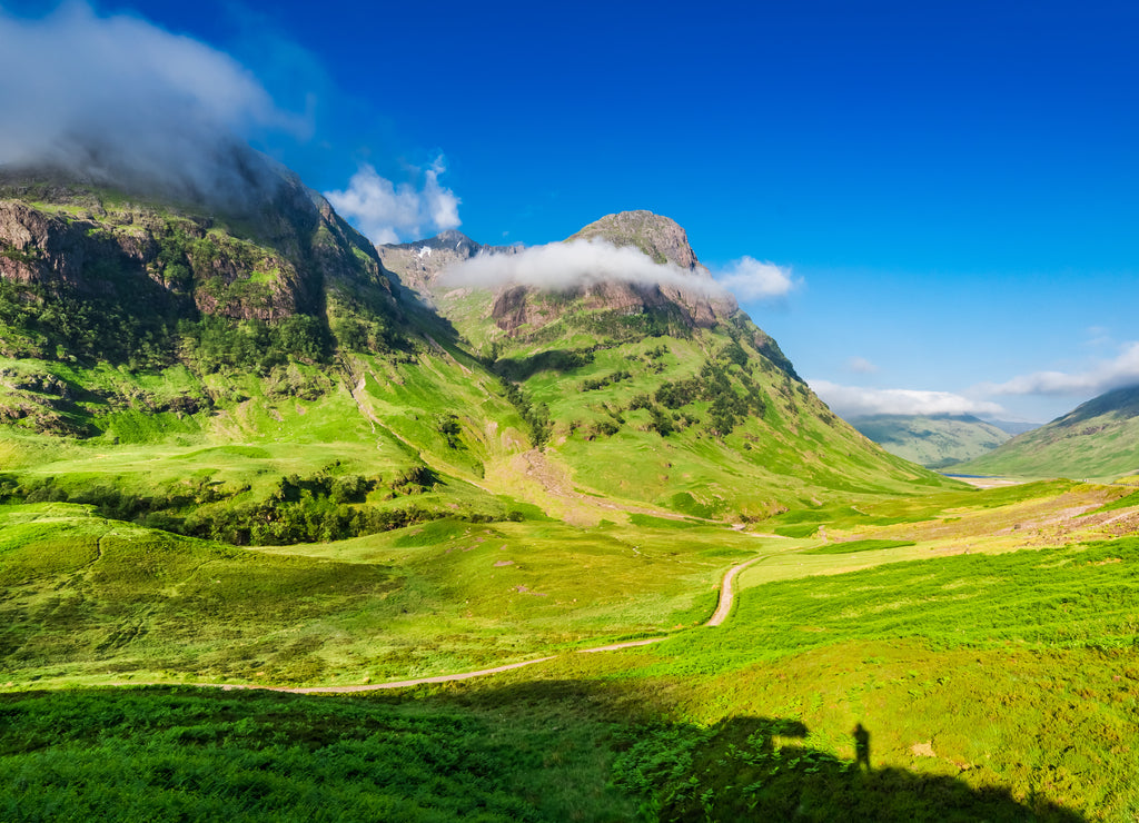 Beautiful sunrise and small man on cliff, Glencoe, Scotland