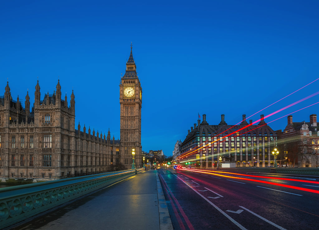 London, England - The famous Big Ben and Houses of Parliament with lights of double decker buses taken on Westminster Bridge at dawn