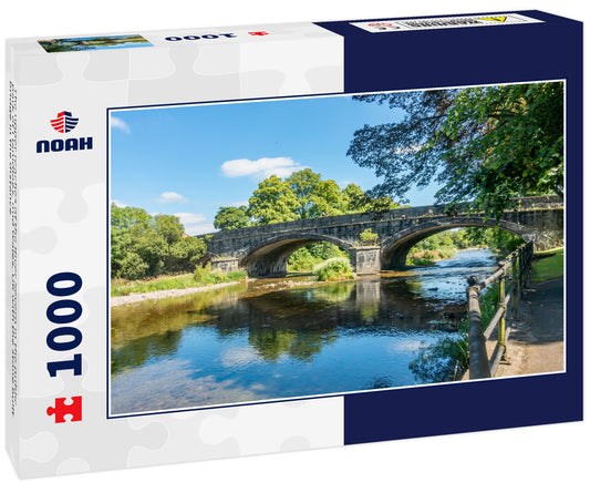The upper reaches of the River Severn in the public park of Llanidloes, mid Wales, UK with the stone built bridge in the distance
