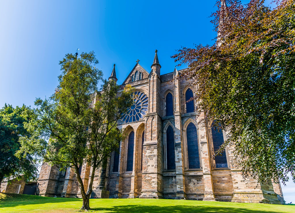 A view through trees towards the cathedral in Durham, UK in summertime