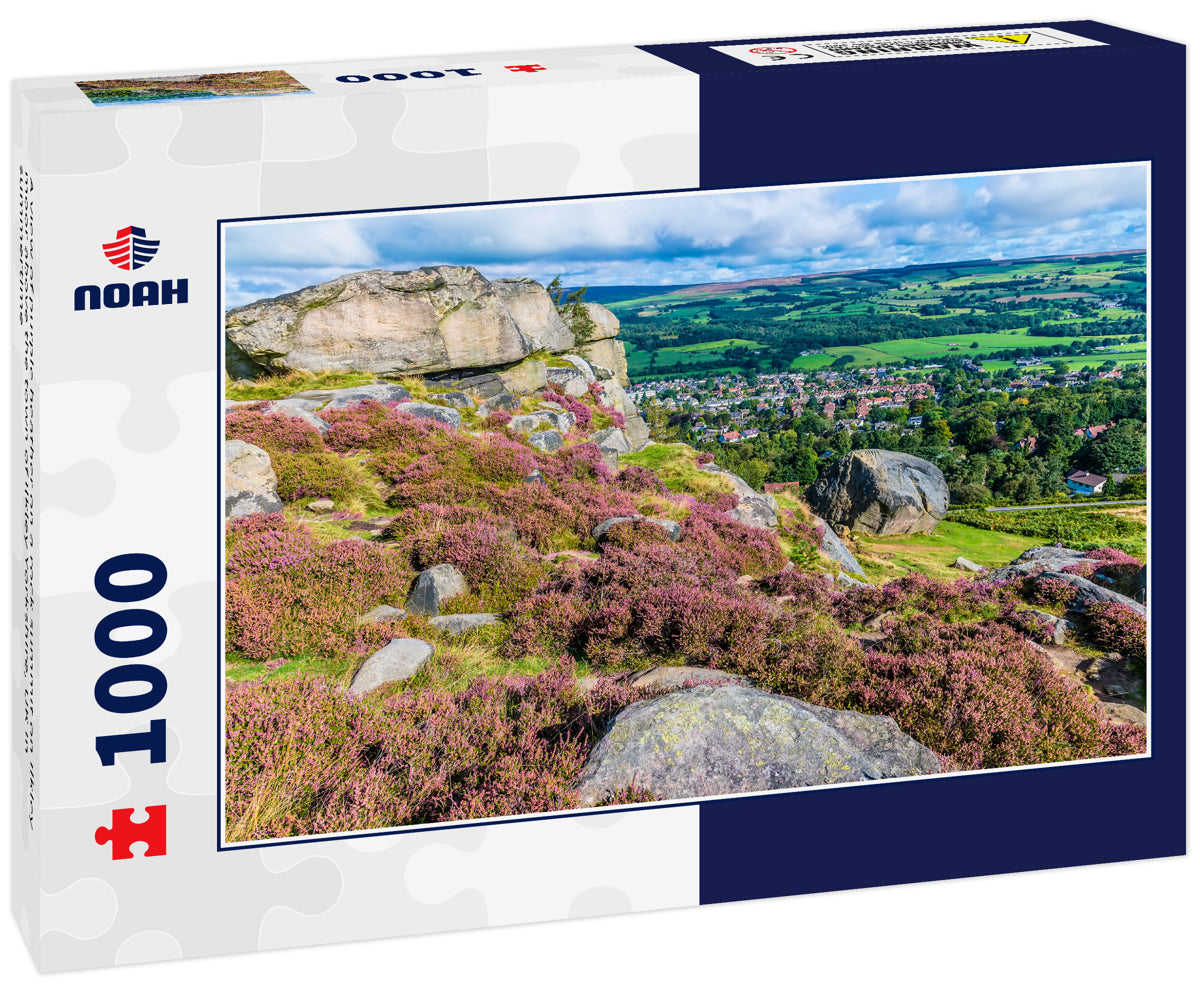 A view of purple heather on a rock summit on Ilkley moor above the town of Ilkley Yorkshire, UK in summertime
