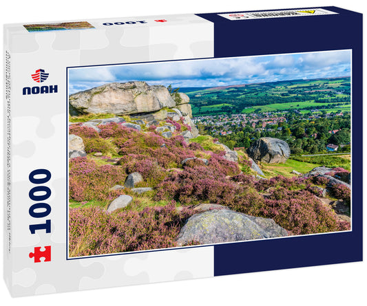 A view of purple heather on a rock summit on Ilkley moor above the town of Ilkley Yorkshire, UK in summertime