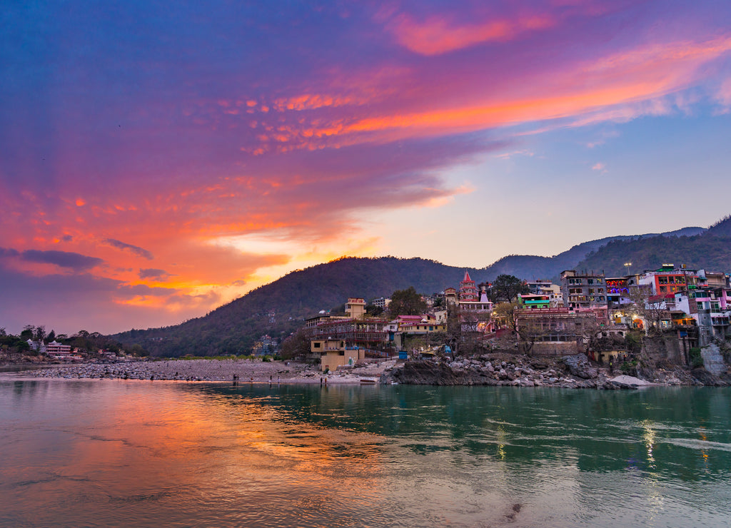 Dusk time at Rishikesh, holy town and travel destination in India. Colorful sky and clouds reflecting over the Ganges River
