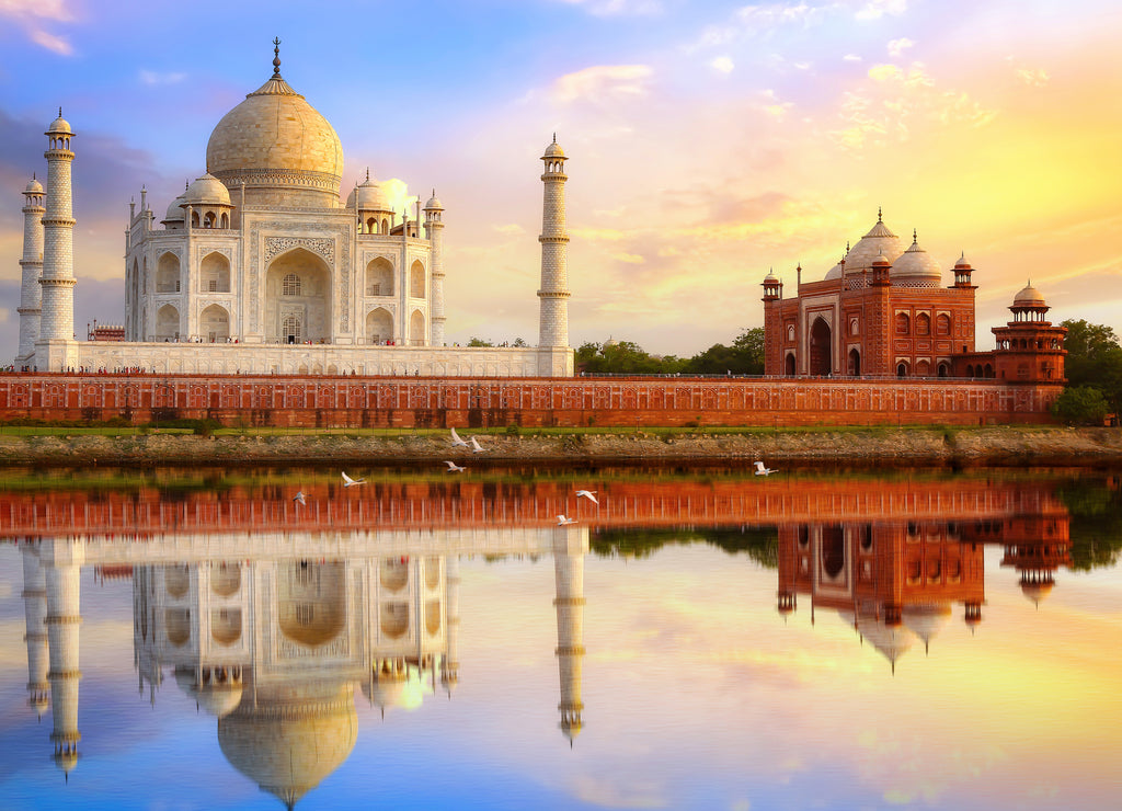 Taj Mahal Agra at sunset with water reflection and moody sky. Taj Mahal is a UNESCO World Heritage site on the banks of river Yamuna at Uttar Pradesh India