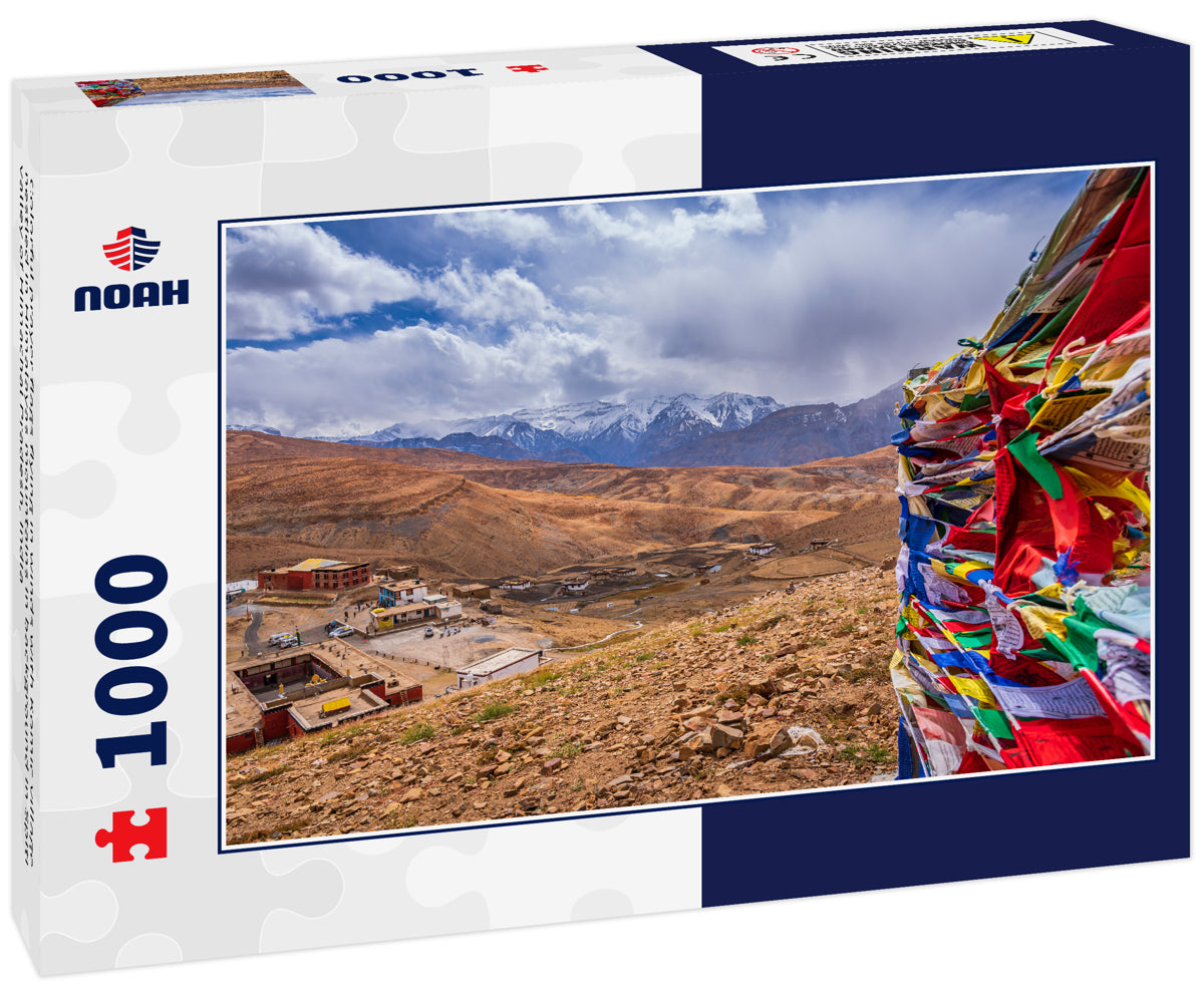 Colorful prayer flags flying in winds with Komic village nestled in Himalayas mountains in background in Spiti valley of Himachal Pradesh, India