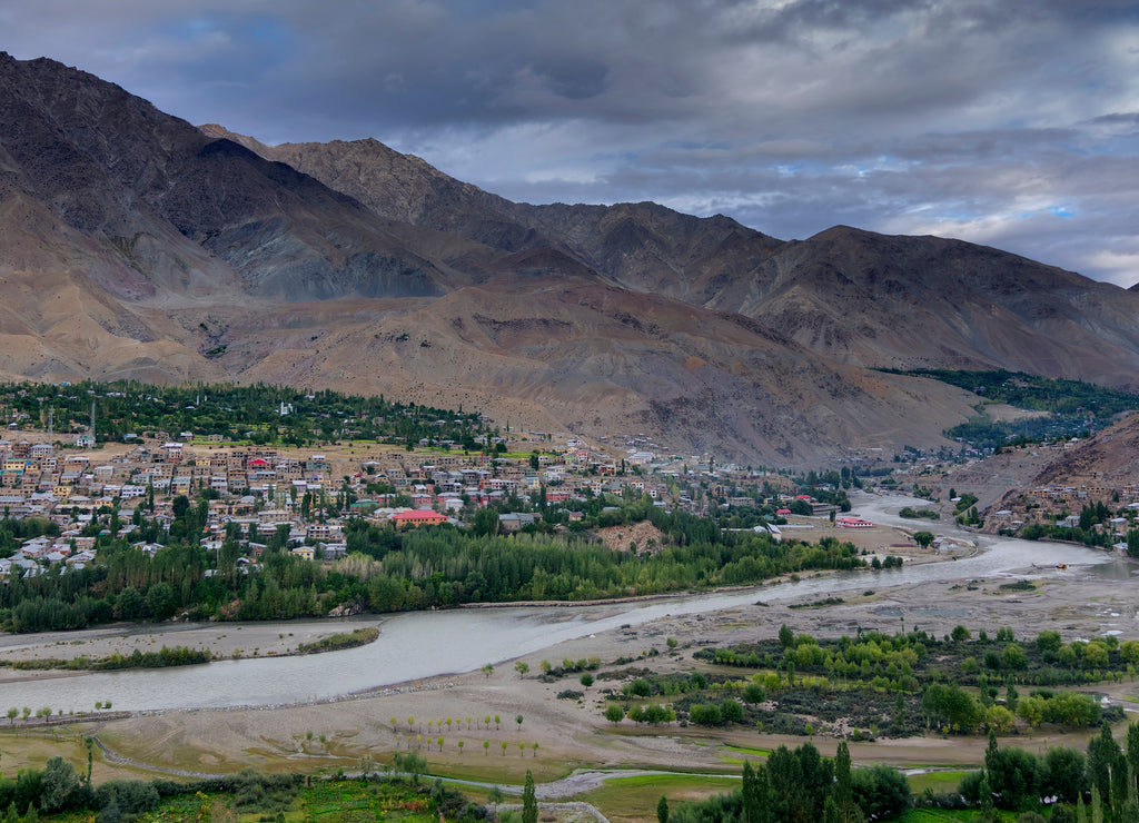 Panoramic view of Indus river and Kargil City valley with Himalayan mountains and blue cloudy sky in background, Leh, Ladakh, Jammu and Kashmir, India