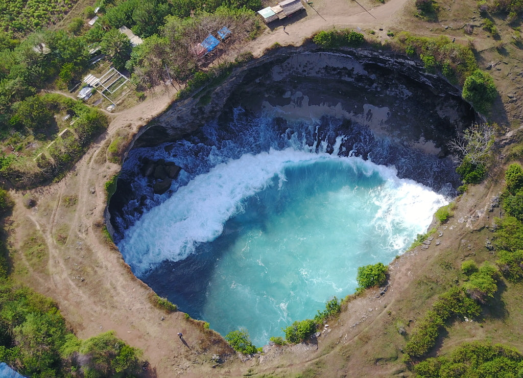Big hole exotic destination tropical travel vacation nature ocean waves shades of blue paradise Bali preservation nature vegetation forest cliff sea travel Indonesia summer